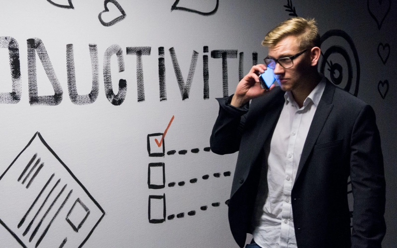 A man walking in front of a white board that says PRODUCTIVITY